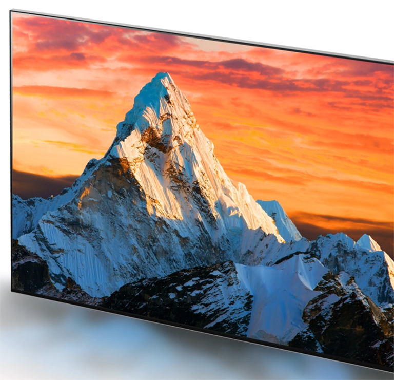 Un écran de téléviseur montrant une montagne avec un couché de soleil orange imposant sa lumière et augmentant la clarté des détails à l'écran (lire la vidéo).